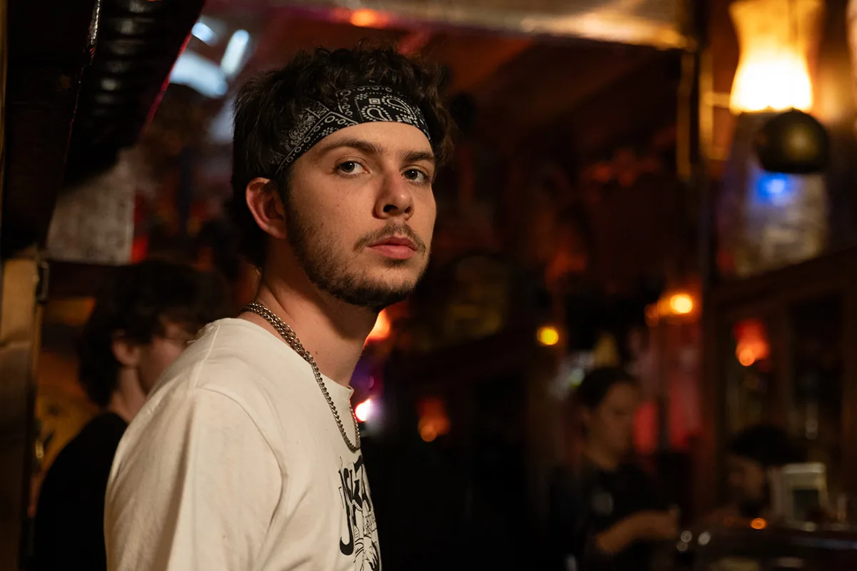 Retrato de un joven con bandana en un bar con luz cálida