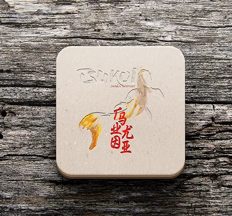 Posavasos de piedra con el logotipo de Tsukoi sobre una mesa de madera